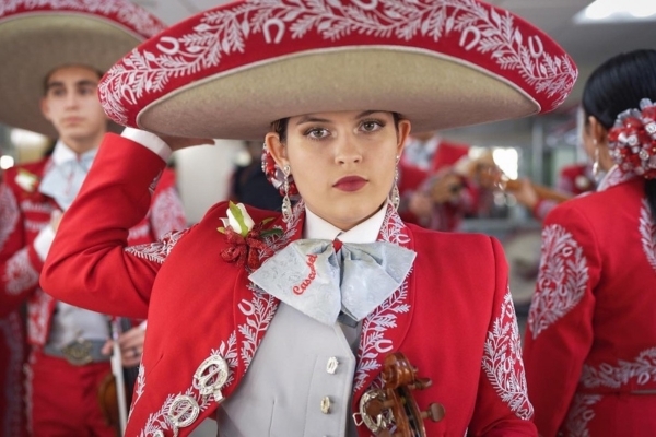 High school student in full mariachi uniform gazing into camera