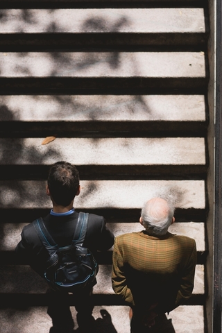 Image Description: Overhead view of an elderly man and younger man ascending stairs